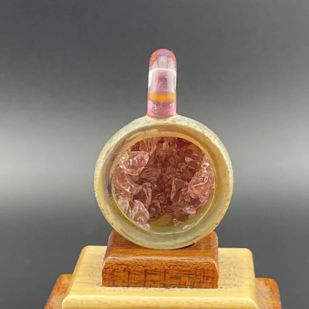 Decorative item with pink interior on a wooden stand against a dark background